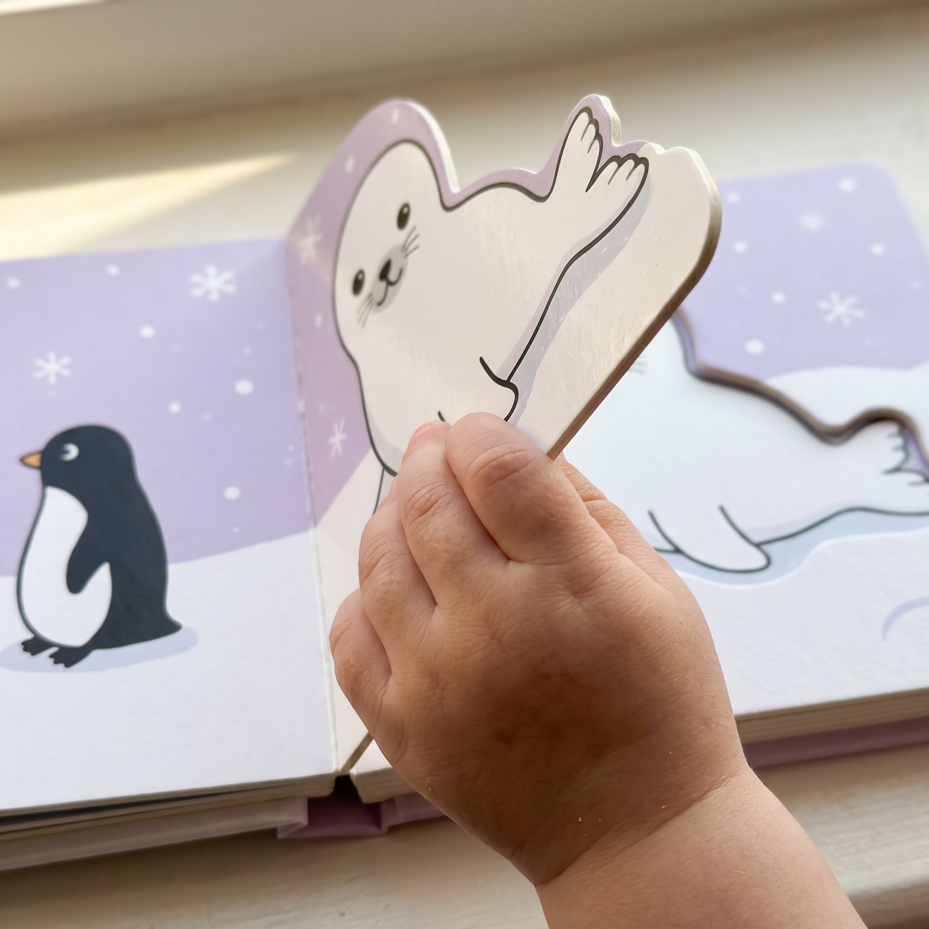 A toddler lifting a die-cut board flap
